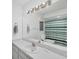 Well-lit bathroom with a large mirror, single sink vanity, and shower/tub combo at 11869 Newgate Ave, Port Charlotte, FL 33981