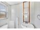 Bathroom showcasing white tile, a sink, mirror, and window for ample natural light at 11869 Newgate Ave, Port Charlotte, FL 33981