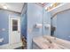 Bright bathroom with blue walls, fun wallpaper trim, and a shower/tub at 11869 Newgate Ave, Port Charlotte, FL 33981