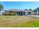 Charming single-story home featuring a screen door and a lush, green lawn at 11869 Newgate Ave, Port Charlotte, FL 33981
