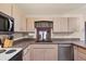 Traditional kitchen featuring wood cabinets, dark countertops, and a sink under the window at 11869 Newgate Ave, Port Charlotte, FL 33981