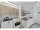 Convenient laundry room with washer, dryer, storage cabinets, and utility sink at 11869 Newgate Ave, Port Charlotte, FL 33981
