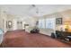 Spacious living room with carpet flooring and a ceiling fan, creating a welcoming atmosphere at 11869 Newgate Ave, Port Charlotte, FL 33981