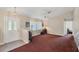 Inviting living room with carpet, a ceiling fan, and a view into another room at 11869 Newgate Ave, Port Charlotte, FL 33981