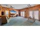 Large living room with wood paneling, ceiling fans, and access to the outdoors at 11869 Newgate Ave, Port Charlotte, FL 33981