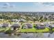 Aerial view of homes in a waterfront community, featuring manicured lawns, mature trees and screened in pools at 119 Fairway Rd, Rotonda West, FL 33947
