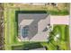 Bird's eye view of a home with a screened-in pool, well-manicured lawn and mature landscaping at 119 Fairway Rd, Rotonda West, FL 33947