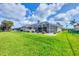 Expansive backyard with lush green lawn and a screened-in pool area at 119 Fairway Rd, Rotonda West, FL 33947