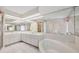 Bright bathroom with a soaking tub, dual sinks, and large mirrors at 119 Fairway Rd, Rotonda West, FL 33947