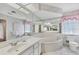 Bathroom featuring a soaking tub, toilet, and vanity with a large mirror at 119 Fairway Rd, Rotonda West, FL 33947