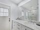Bright bathroom featuring dual sinks, marble countertop, and large mirror at 119 Fairway Rd, Rotonda West, FL 33947