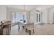 Elegant dining area featuring light tile flooring, a glass dining table with seating, and modern lighting fixtures at 119 Fairway Rd, Rotonda West, FL 33947