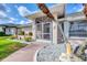 Close up of the entryway featuring a screened-in porch and a well landscaped yard at 119 Fairway Rd, Rotonda West, FL 33947
