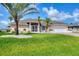 Charming single-story home with lush lawn, palm trees, and a well-manicured landscape at 119 Fairway Rd, Rotonda West, FL 33947