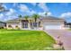 Charming single-story home with a lush green lawn, screened porch, and a two-car garage at 119 Fairway Rd, Rotonda West, FL 33947