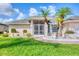 Inviting home exterior with lush green lawn, well-manicured landscaping, and a charming screened entryway at 119 Fairway Rd, Rotonda West, FL 33947
