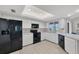 Functional kitchen featuring white cabinets, black appliances, and a window view to the outdoors at 119 Fairway Rd, Rotonda West, FL 33947