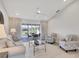 Bright living room featuring light wood floors and a sliding door view to the pool at 119 Fairway Rd, Rotonda West, FL 33947