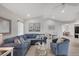 Cozy living room showcasing a comfortable blue sectional sofa, a glass coffee table, and a bright open floor plan at 119 Fairway Rd, Rotonda West, FL 33947