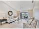 Bright living room featuring light wood floors and a sliding door view to the pool at 119 Fairway Rd, Rotonda West, FL 33947