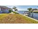 Waterfront home featuring a well-maintained lawn and a private dock for boating enthusiasts at 12445 Krome Ave, Port Charlotte, FL 33981