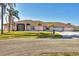 Charming single-story home featuring a three-car garage, arched windows, and mature landscaping at 12445 Krome Ave, Port Charlotte, FL 33981
