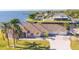 Sprawling waterfront home with mature palm trees, a long driveway, and an attached two car garage at 12445 Krome Ave, Port Charlotte, FL 33981