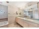 View of the main bathroom featuring a long vanity with dual sinks, soaking tub and tiled shower at 12445 Krome Ave, Port Charlotte, FL 33981