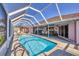 Outdoor pool, covered by a screen enclosure, providing a refreshing retreat with views of the property at 12445 Krome Ave, Port Charlotte, FL 33981