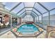 Enclosed pool area featuring a spa and waterfront views, perfect for year-round enjoyment at 12445 Krome Ave, Port Charlotte, FL 33981