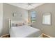 Comfortable bedroom with a large window and light-colored walls, and a white-themed bed at 1318 Ballota Ln, North Port, FL 34289