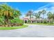 Beautiful clubhouse entrance with manicured landscaping, circular drive, and covered portico at 1318 Ballota Ln, North Port, FL 34289