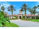 Well-manicured landscaping surrounds the clubhouse entrance, framed by tall palm trees at 1318 Ballota Ln, North Port, FL 34289