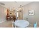 Open dining area with modern chandelier, bar seating, and sliders to outside at 1318 Ballota Ln, North Port, FL 34289