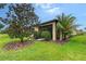 House exterior with a lush green yard, a tree, and a screened patio at 1318 Ballota Ln, North Port, FL 34289
