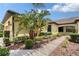 Exterior view of home with verdant landscaping and concrete walkway at 1318 Ballota Ln, North Port, FL 34289