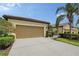 Attached two-car garage with palm tree in front yard with manicured lawn at 1318 Ballota Ln, North Port, FL 34289