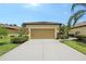 Attached two-car garage in well-manicured front yard with shrubbery and trees at 1318 Ballota Ln, North Port, FL 34289