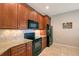 Kitchen with wood cabinets, granite countertops, tile backsplash, and black appliances at 1318 Ballota Ln, North Port, FL 34289
