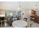 Open-concept living room with modern lighting, tile floors, bar seating, and slider to outside at 1318 Ballota Ln, North Port, FL 34289
