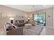 Beautiful living room with large rug, slider to screen porch, neutral walls and comfy couches at 1318 Ballota Ln, North Port, FL 34289