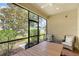 Enclosed patio with a ceiling fan and comfortable seating area with views of the green yard at 1318 Ballota Ln, North Port, FL 34289