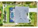 Aerial view of a house with a screened-in pool, well-manicured lawn, and mature landscaping at 13348 Boabadilla Ln, Port Charlotte, FL 33981