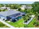 Expansive backyard with a screened-in pool, covered patio, and lush palm trees offering a serene retreat at 13348 Boabadilla Ln, Port Charlotte, FL 33981