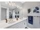 Bright bathroom with dual sinks, large mirror, white cabinets, and blue decorative towels at 13348 Boabadilla Ln, Port Charlotte, FL 33981