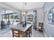 Bright dining room with sliding glass doors to patio and a modern chandelier above a wood table at 13348 Boabadilla Ln, Port Charlotte, FL 33981