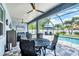 Relaxing screened-in lanai with a ceiling fan, dining table, tv, and a view of the beautiful pool area at 13348 Boabadilla Ln, Port Charlotte, FL 33981