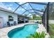 Resort-style pool in screened lanai with covered patio, comfortable seating, and lush landscaping at 13348 Boabadilla Ln, Port Charlotte, FL 33981