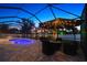 Outdoor living space featuring a screened pool, elegant patio furniture, and ambient lighting at 13348 Boabadilla Ln, Port Charlotte, FL 33981