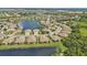 Scenic aerial view of a community featuring a large lake surrounded by beautiful homes at 1339 Backspin Dr, Englewood, FL 34223